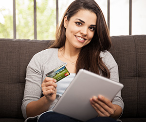 woman holding a tablet and credit card